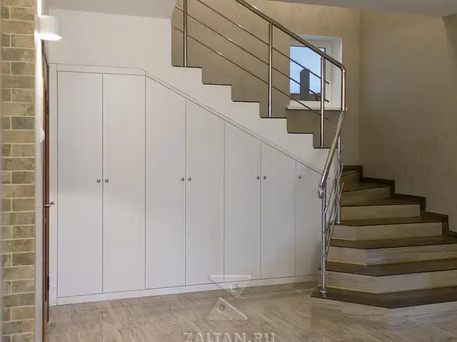 Белый шкаф под лестничном пространстве